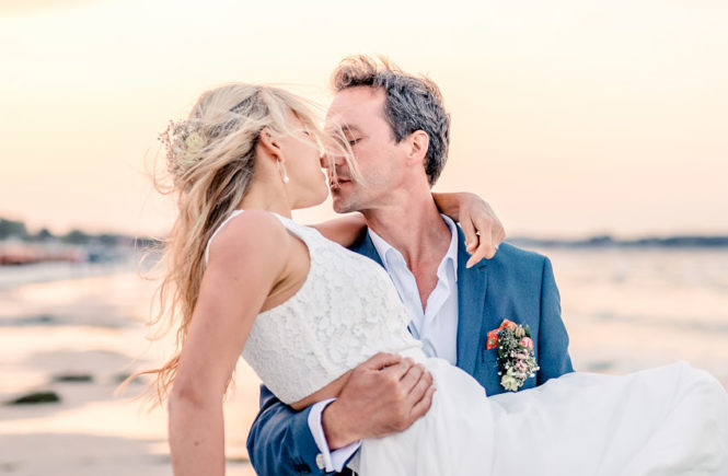Brautpaar Pose küsst sich am Strand